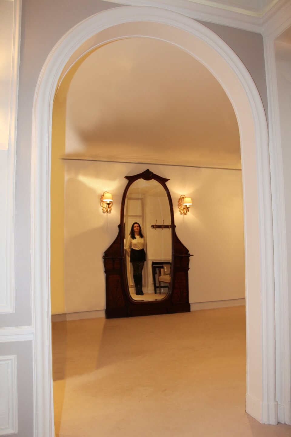 reflet d'Amélie dans un miroir ovale sur pied.
